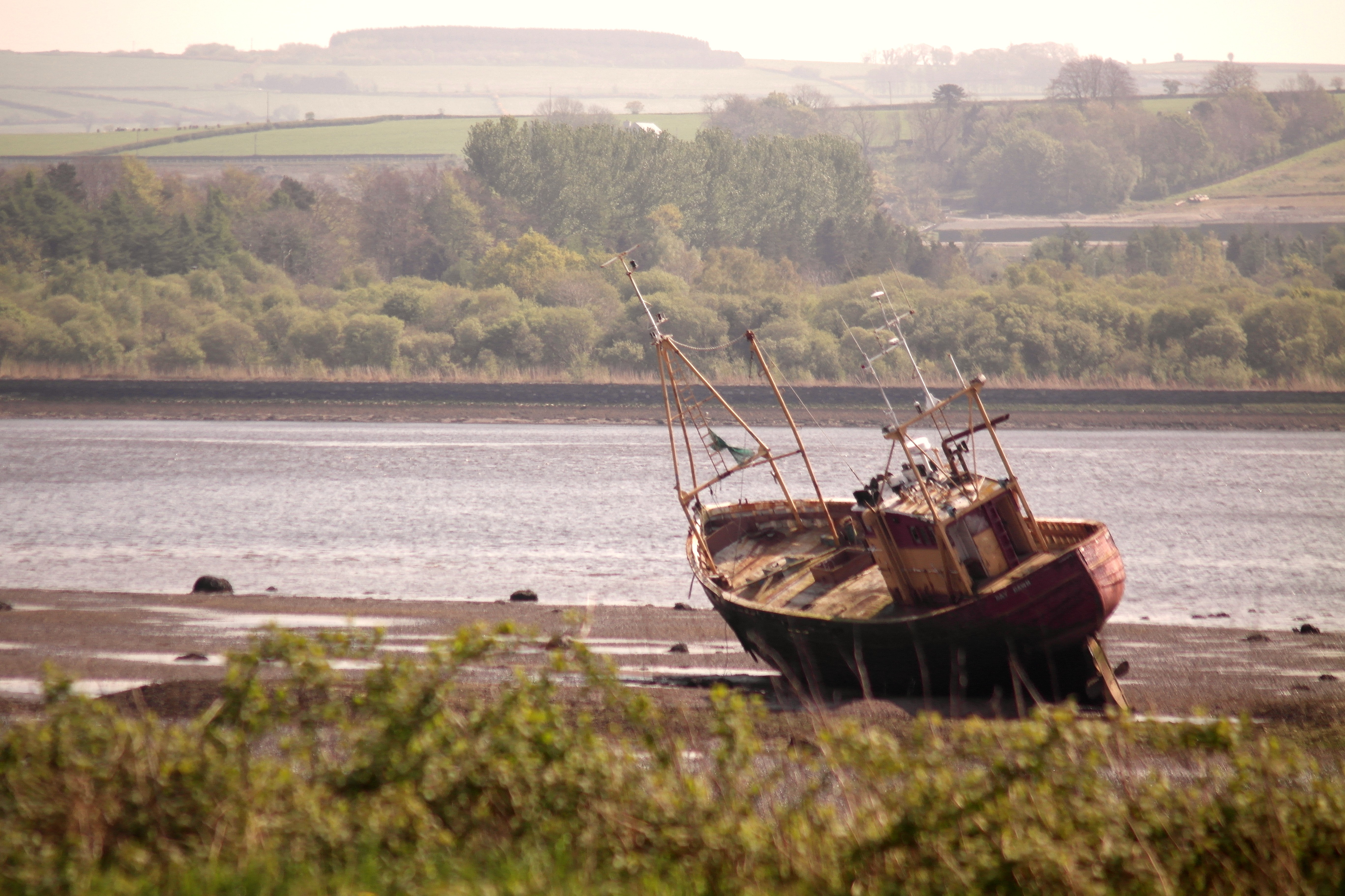 Small sailboat stuck in the River Foyle in Derry, Ireland. The boat became stuck in August 2020 and has remained since.